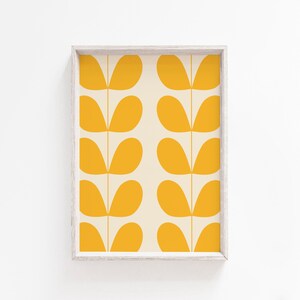 May include: A framed print with a repeating pattern of yellow leaf shapes on a cream background.
