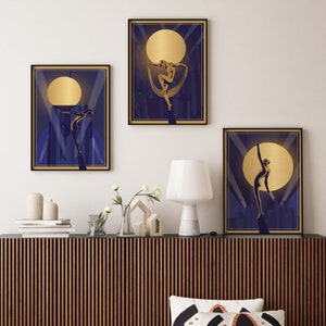 May include: Three framed art prints with a gold and blue color scheme. Each print features a stylized silhouette of a person in a dancing pose against a backdrop of a city skyline and a large, golden moon.