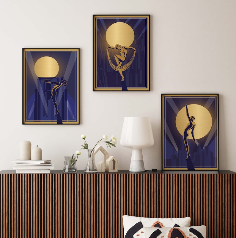 May include: Three framed art prints with a gold and blue color scheme. Each print features a stylized silhouette of a person in a dancing pose against a backdrop of a city skyline and a large, golden moon.