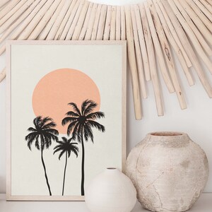 May include: A framed print with a minimalist design featuring three palm trees silhouetted against a peach-colored sun on a beige background.