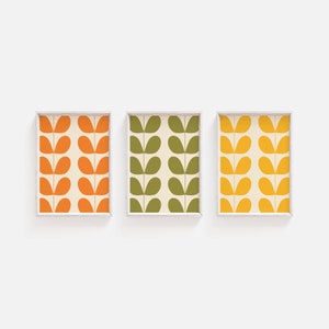May include: Three framed prints with a repeating pattern of stylized green, orange, and yellow leaves on a white background.
