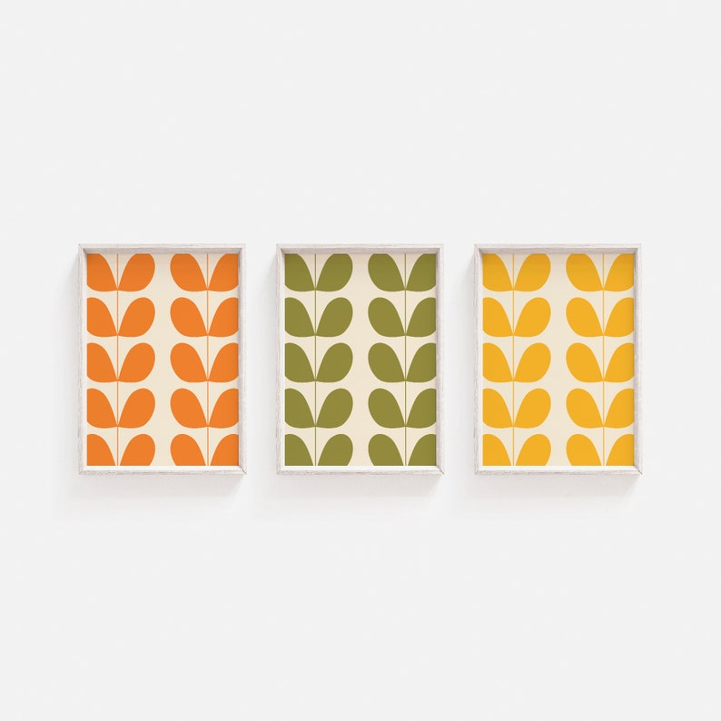 May include: Three framed prints with a repeating pattern of stylized green, orange, and yellow leaves on a white background.
