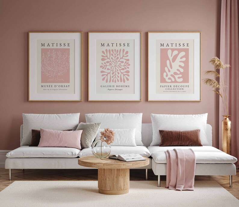 May include: Three framed art prints with a pink background and white line drawings of abstract floral designs. The prints are titled "Matisse" and feature the text "Mus&eacute;e d'Orsay", "Galerie Boh&egrave;me", and "Papier D&eacute;coup&eacute; Collection".
