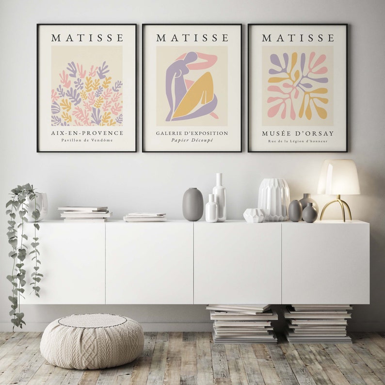 May include: Three framed art prints with a minimalist design featuring abstract shapes in pink, yellow, and purple. The prints are titled "MATISSE" and each features a different location: "AIX-EN-PROVENCE", "GALERIE D'EXPOSITION", and "MUS&Eacute;E D'ORSAY".