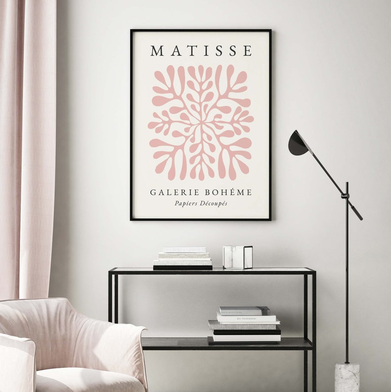 May include: A black framed poster with the text "MATISSE" and "GALERIE BOHEME" in white. The poster features a pink abstract design with the text "Papiers D&eacute;coup&eacute;s" in white.
