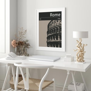 Peut inclure: Une impression encadr&eacute;e blanche avec une illustration en noir et blanc du Colis&eacute;e &agrave; Rome, en Italie. Le texte "Rome" et "Italie" est imprim&eacute; en noir sur fond noir.