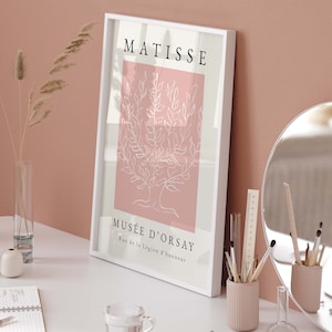 May include: A white framed print with a pink background and a white line drawing of a tree. The text "MATISSE" is at the top of the print and "MUS&Eacute;E D'ORSAY" is at the bottom with the address "Rue de la L&eacute;gion d'honneur".