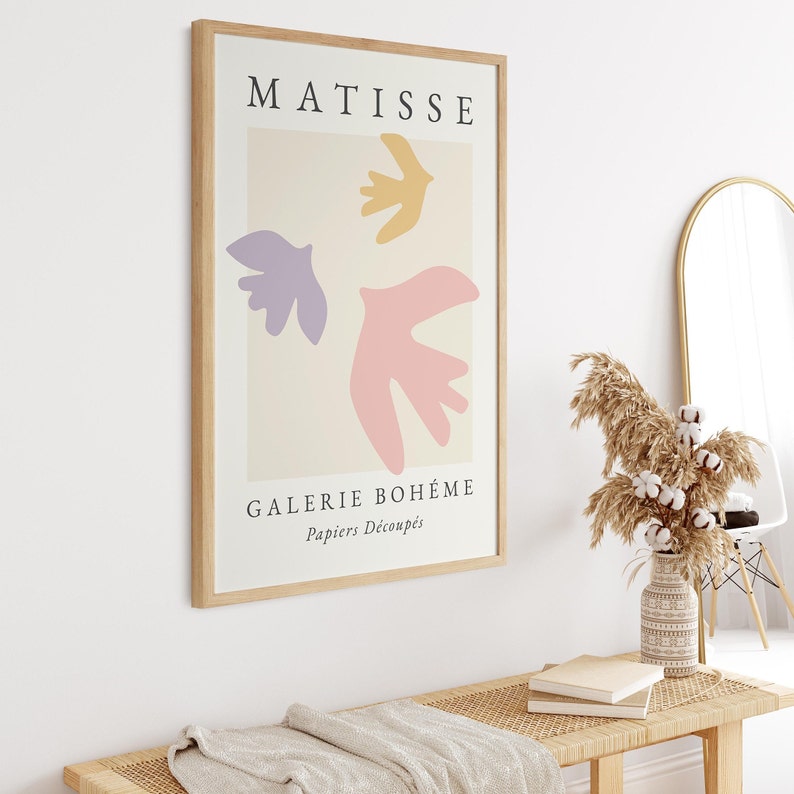 May include: A framed art print with a light beige background featuring three abstract shapes in pink, purple, and yellow. The print has the text "MATISSE" at the top and "GALERIE BOHEME Papiers Decoupes" at the bottom.