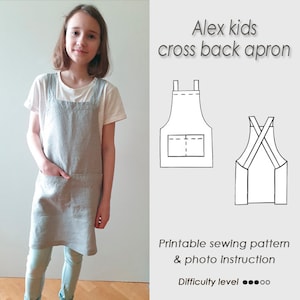 May include: A printable sewing pattern for a kids' cross back apron. The pattern includes a photo instruction guide and is rated easy to sew. The image shows a child wearing a gray linen apron.