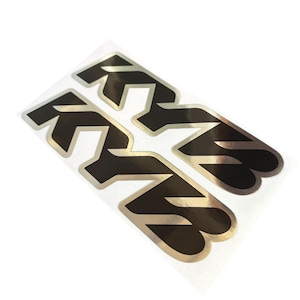 May include: Set of four black and silver stickers. Each sticker features the letters "KN" in a stylized font. The stickers are on a clear backing and are angled slightly to the right against a white background.