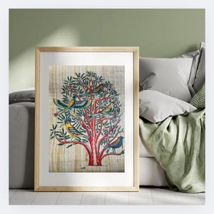 May include: Framed artwork featuring a tree with red branches and green leaves, adorned with colorful birds. The birds have blue, yellow, and green plumage. The artwork is set against a light-colored background, framed in a light wood frame.