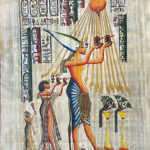 May include: An Egyptian papyrus painting depicting figures in traditional attire. The central figure, adorned with a tall headdress, holds objects aloft. The artwork features hieroglyphs, a sun, and stylized rays, with a color palette of gold, blue, and brown.