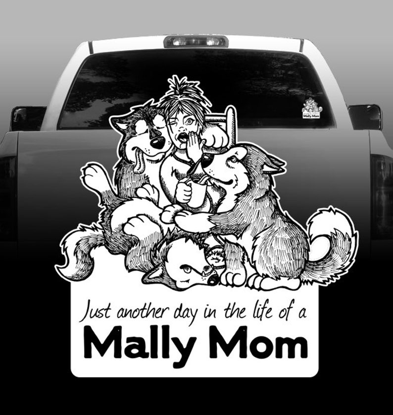 Pu&ograve; includere: Illustrazione in bianco e nero di una donna con tre cani. La donna &egrave; seduta su una sedia e i cani la circondano. Il testo "Just another day in the life of a Mally Mom" &egrave; sotto l'immagine.