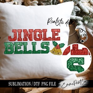 Op de afbeelding: Een wit kussen met de tekst "Jingle Bells" in rode en groene glitterletters. De letters hebben een 3D-effect en zijn zwart omrand. Aan de rechterkant van het kussen is een kleine gouden bel met een rode hulsttak. De tekst "Realistic detail" staat in het zwart bovenaan het kussen. Het kussen ligt op een houten oppervlak.