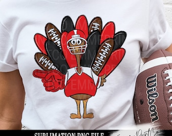 Puede incluir: Camiseta blanca con un pavo de dibujos animados que lleva un casco y una camiseta de fútbol, con un dedo de espuma rojo. Las plumas de la cola del pavo están diseñadas como balones de fútbol. El texto "SUBMLIMATION PNG FILE" está en la parte inferior.