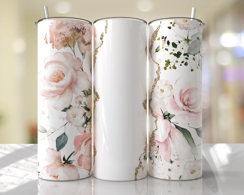 Puede incluir: Tres vasos de acero inoxidable con un dise&ntilde;o floral. Los vasos son blancos con un patr&oacute;n floral rosa y verde. El patr&oacute;n incluye rosas y hojas. Los vasos tienen un acento de brillo dorado.