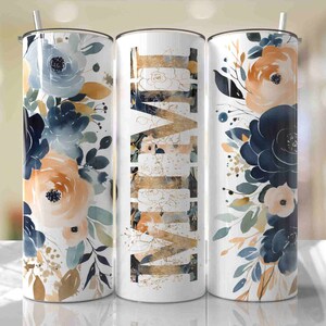 Peut inclure: Trois gobelets en acier inoxydable avec un motif floral. Les gobelets présentent un motif de style aquarelle avec des fleurs bleues, orange et blanches. Le gobelet du milieu porte le mot "LOVE" écrit en lettres dorées.