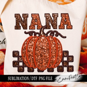 Puede incluir: Una bolsa de lona blanca con la palabra "NANA" en letras de purpurina marrón y una calabaza de purpurina marrón con un tallo y una vid. El texto "SUBLIMATION/ DTF PNG FILE" está en la parte inferior de la bolsa.