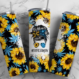 May include: A stainless steel tumbler with a black background and a design of sunflowers, marijuana leaves, and a woman with sunglasses and a bandana. The text "#DOPESTMOM" is printed on the tumbler.