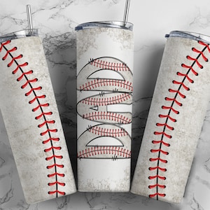 May include: Three stainless steel tumblers with a baseball theme. The tumblers are white with red stitching and a baseball design.
