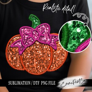 May include: A sublimation or DTF print design featuring a pumpkin with a pink bow. The pumpkin is made of orange sequins and the bow is made of pink sequins. The design is on a black t-shirt. The text "Realistic detail!" and "Sublimation/ DTF PNG File" are also visible on the image.