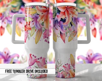 May include: Two white stainless steel tumblers with a floral design. The tumblers have a handle and a lid. The design features pink, purple, and yellow lilies with watercolor splatters.