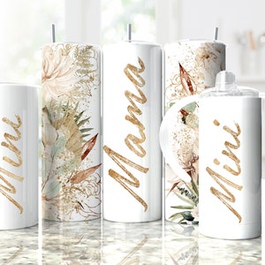 Könnte beinhalten: Set aus drei weißen Bechern mit goldener Beschriftung und Blumenmuster. Die Becher zeigen "Mama", "Mini" und "Mini".