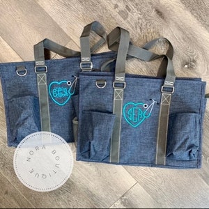 May include: Two blue tote bags with gray straps and a heart-shaped monogram with a stethoscope. The monogram on the left bag says "GGG" and the monogram on the right bag says "SEB".