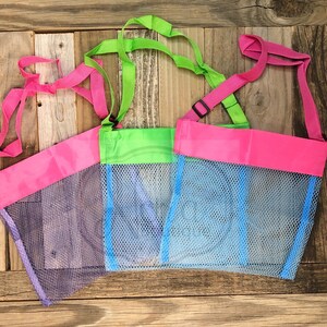 May include: Three mesh bags with pink, green, and blue trim. The bags have adjustable straps and are made of a fine mesh material.