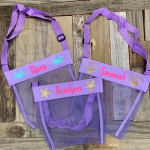 May include: Three purple mesh bags with adjustable straps. Each bag has a different sea creature design and a personalized name: Iliana, Brinlynn, and Savannah.