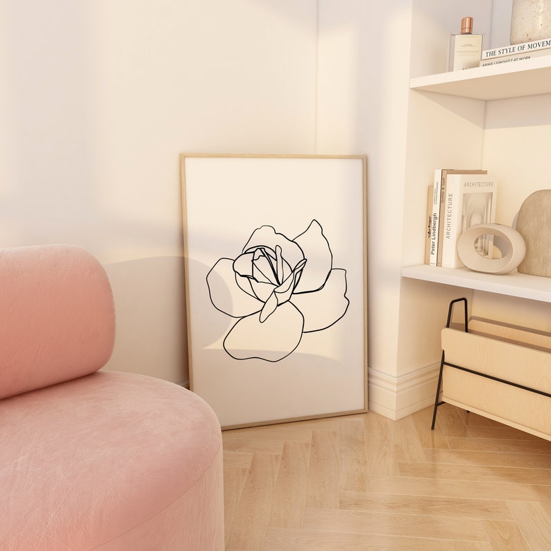 Puede incluir: Un dibujo en blanco y negro de una rosa en un estilo simple y moderno. El dibujo est&aacute; enmarcado y colgado en una pared blanca.