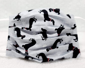 May include: A white face mask with a black dachshund pattern. The mask has white elastic ear loops.