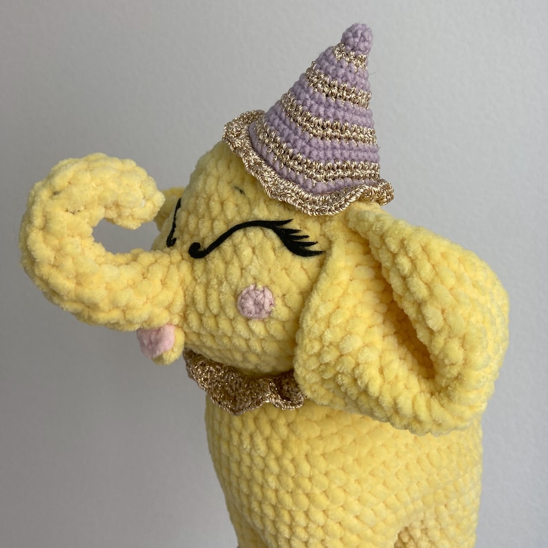 a crocheted elephant with a hat on its head