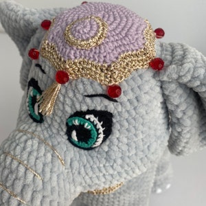 a crocheted elephant with a hat on its head