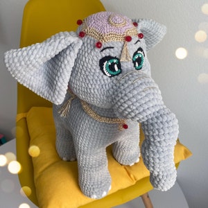 a stuffed elephant sitting on top of a yellow chair