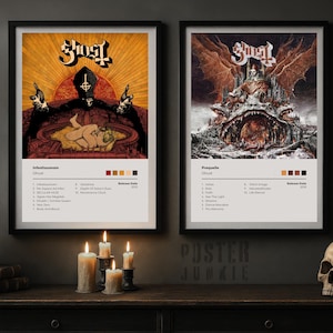 May include: Two framed posters featuring artwork for the band Ghost's albums, Infestissumam and Prequelle. The Infestissumam poster has a yellow and red color scheme, while the Prequelle poster has a brown and orange color scheme. A crow statue, candles, and a skull are on the table.