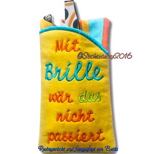 May include: Yellow fabric pouch with a blue and orange striped pocket. The pouch has embroidered text that reads "Mit Brille war das nicht passiert" and "@Stichezauber2016".