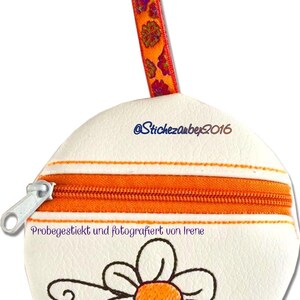 May include: White round zippered pouch with an orange zipper and orange trim. The pouch has a small embroidered flower with an orange center. The pouch has a loop with a key ring and an orange ribbon with floral print.