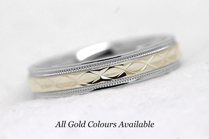 Pode incluir: Uma alian&ccedil;a de dois tons com um padr&atilde;o de diamante no centro. A banda &eacute; feita de ouro branco e amarelo. "Todas as cores de ouro dispon&iacute;veis" est&aacute; escrito abaixo da banda.