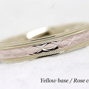 Pode incluir: Uma alian&ccedil;a de ouro com uma banda central de ouro rosa. A banda central tem um padr&atilde;o de diamante.