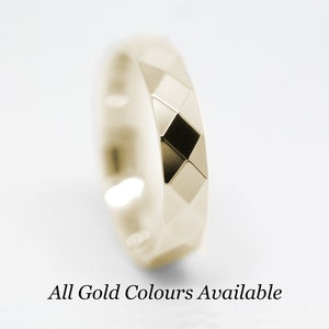 May include: A gold wedding band with a geometric design. All gold colors are available.