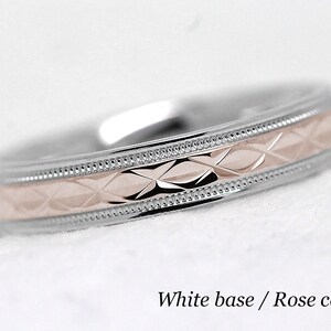 Pode incluir: Uma alian&ccedil;a de ouro branco com uma banda central de ouro rosa. A banda central tem um padr&atilde;o de diamante.