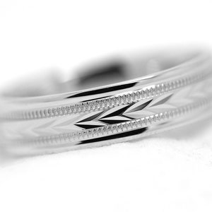 May include: A silver wedding band with a diamond-cut design.