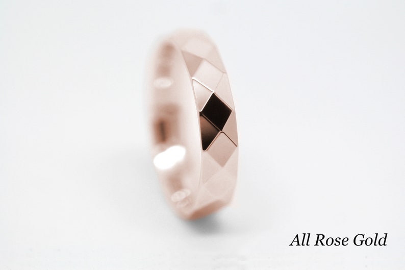 May include: A rose gold wedding band with a geometric design. The band is made of a smooth, polished metal and has a slightly rounded edge. The band is a simple and elegant design that would be perfect for a wedding or engagement ring.