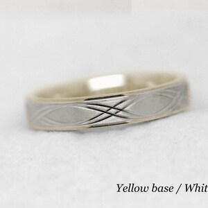 May include: A gold wedding band with a white gold center band. The center band has a Celtic knot design.