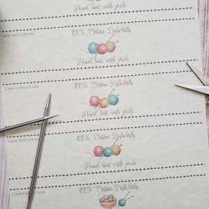 May include: Five printable labels for hand-knitted dishcloths. Each label features a watercolor illustration of yarn balls and knitting needles, and the text "100% Cotton Dishcloths" and "Hand knit with pride".