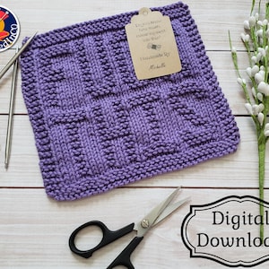 Peut inclure: Un torchon en tricot violet avec une étiquette qui dit "Savez-vous combien de jurons sont allés dans ça ? Fait main par Michelle". Le torchon est sur une surface en bois blanc avec une paire de ciseaux et une branche de fleurs blanches.