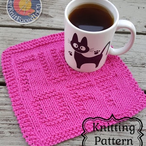 Op de afbeelding: Een roze gebreide theedoek met een eenvoudig patroon. De theedoek ligt op een houten oppervlak met een mok en een logo op de achtergrond. De tekst "Knitting Pattern" is zichtbaar in de rechterbenedenhoek van de afbeelding.