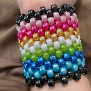 Queer Pride-flagga med pärlemorskimrande Kandi-manschettarmband