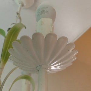 K&ouml;nnte beinhalten: Wei&szlig;er Metall-Kronleuchter mit floralem Design. Der Kronleuchter hat eine wei&szlig;e Gl&uuml;hbirne und eine wei&szlig;e Deckenbefestigung.